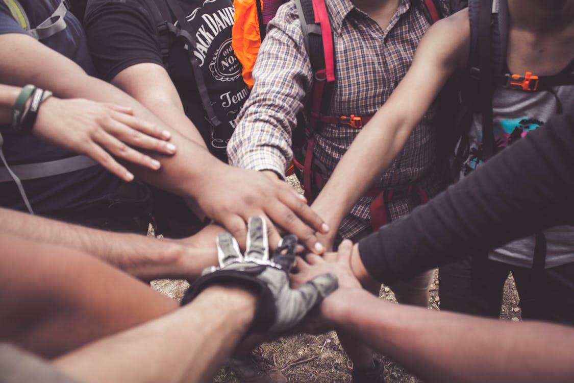 Groupe de personnes joignant leurs mains en cercle, esprit d'équipe et cohésion associative
